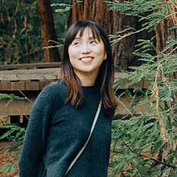 Portrait of Daisy smiling among redwood trees